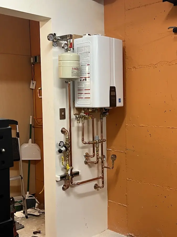 Plumbing technician inspecting water heater connections in Lisbon